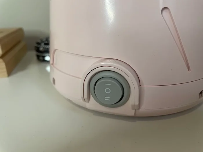 A closeup of the on switch on a Yogasleep Dohm Classic Sound Machine.